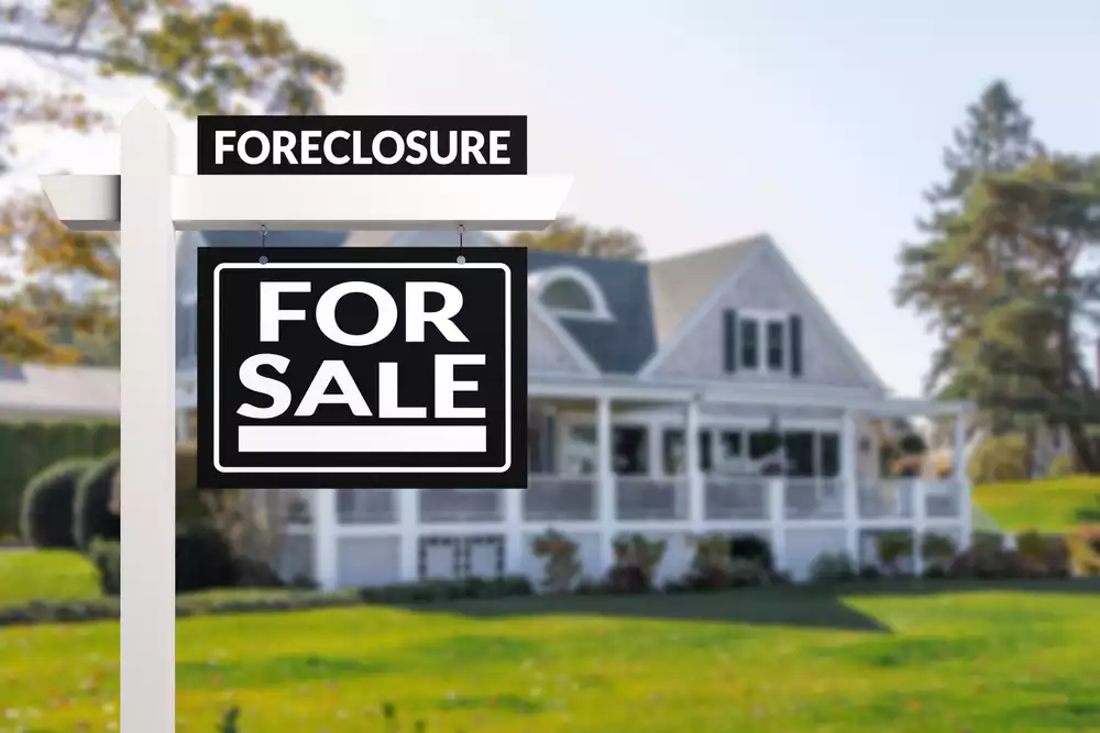 Home in foreclosure with for sale sign in front yard