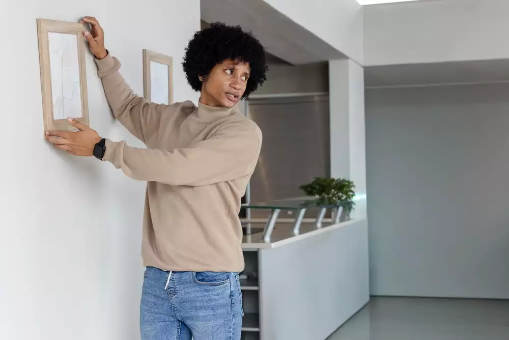 Man hanging up a decorative photo in his modern home